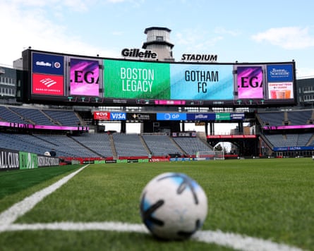 A ball sits on a soccer field with Boston Legacy and Gotham FC displayed on a video board at Gillette Stadium.