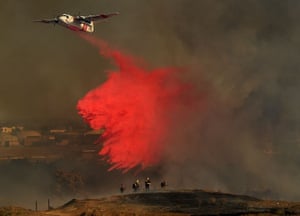 Califórnia, EUA: um avião de combate a incêndios lança Phos-Chek no enorme incêndio do Vale do Jurupa em maio.