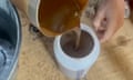 Cloudy oil being poured into a container.