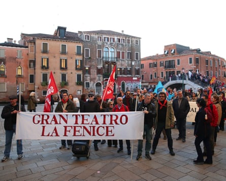 A gathering of people with flags and banners in a square in Venice