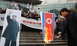 A South Korean protester burns a North Korean flag in opposition to the North’s participation in the Pyeongchang Winter Olympics.