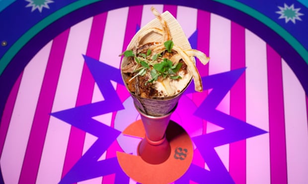 A cone of food on a bright-coloured stripy background