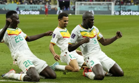 Kalidou Koulibaly slides on his knees with his Senegal teammates after his match-winning goal against Ecuador