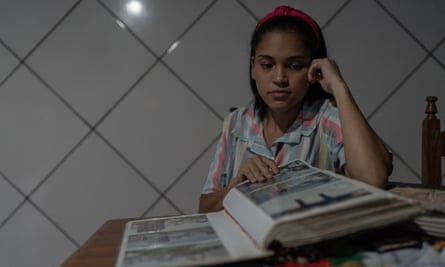 Genifer Oliveira dos Santos, the 28-year-old daughter of Lenilda dos Santos, looks at photo albums with pictures of her mother.