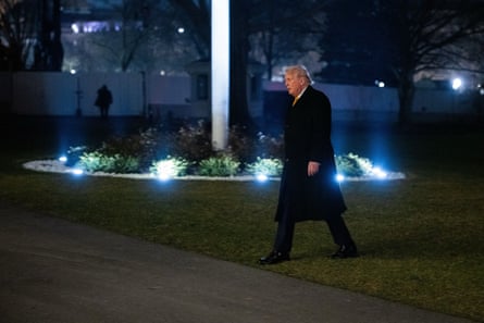 a man in suit walks outside at night