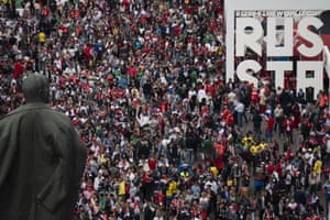 Fans stream past the statue of Lenin as they make their way into Luzhniki stadium