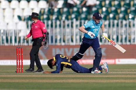 England's Harry Brook runs past fallen Sri Lankan fielder Dunith Wellalage during a match