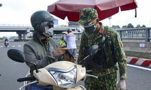 An army soldier checks identifications at a Covid-19 lockdown checkpoint in Ho Chi Minh City, on 23 August.