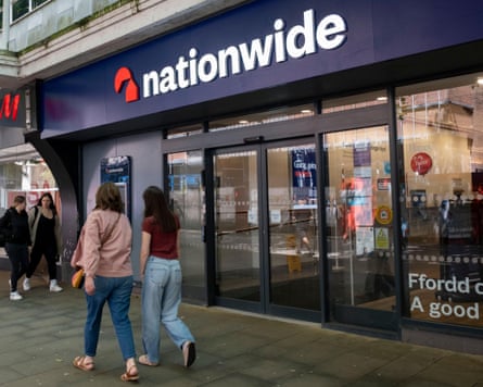 Shoppers pass a branch of Nationwide