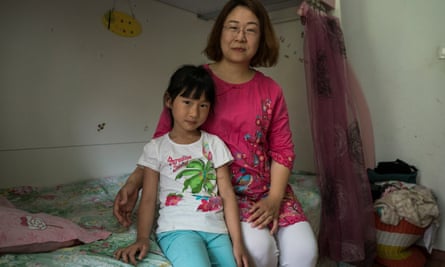 Li Jiamei poses for a portrait with her mother Wang Qiaoling in her bedroom at home in Beijing.