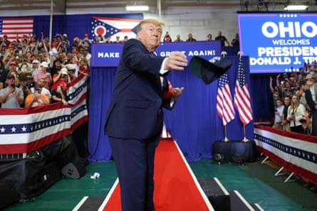 President Donald Trump tosses hats as he walks on stage to speak during a campaign rally at the Shoemaker Center at Ohio University