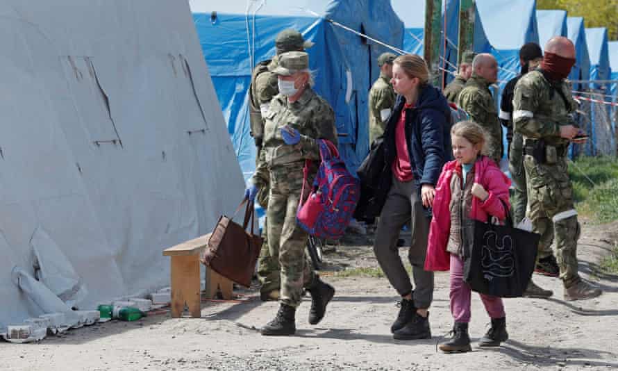 Civilians who left the area near Azovstal steel plant in Mariupol walk accompanied by a service member of pro-Russian troops at a temporary accommodation centre during Ukraine-Russia conflict in the village of Bezimenne in eastern Ukraine. REUTERS/Alexander Ermochenko