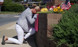 Woman kneeling down at a memorial near the Capital Gazette in Annapolis, Maryland