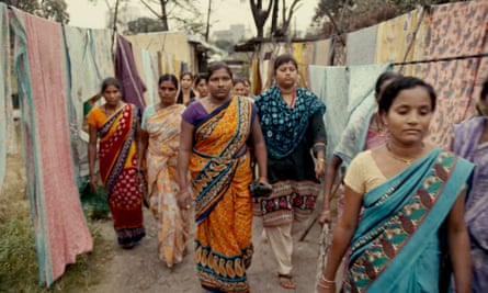 Women in saris walk between washing