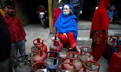 A Nepalese woman waits for a refill of her cooking gas cylinders, in Kathmandu