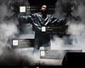 Image of Kanye West on stage surrounded by dry ice, with offensive tweets super-imposed over him