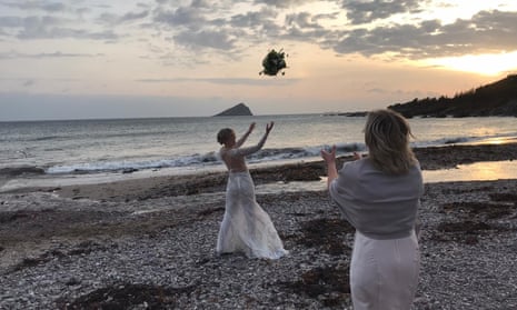 Isobel Burston throws her bouquet at her locked-down wedding in Dorset.
