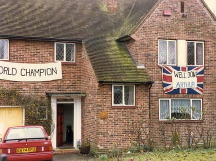 A red-bricked house with a ‘World Champion’ sign and a union flag with ‘Well done, Arthur’ on it, hanging on the front