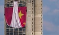 Workers install a giant Chinese national flag on a skyscraper in Belgrade.