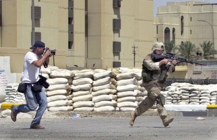 a photographer runs while a photographing a running soldier