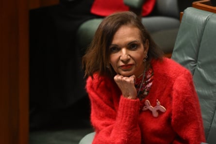 Anne Aly rests her chin on her hand with a serious expression during Question Time