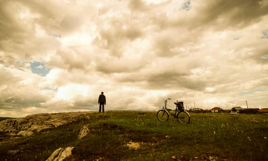 Caucasian man with bicycle in field