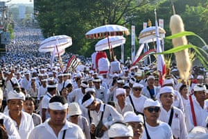 Crowds of people wearing white in a procession