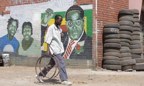 A man walks past a mural depicting Robert Mugabe in Harare, Zimbabwe