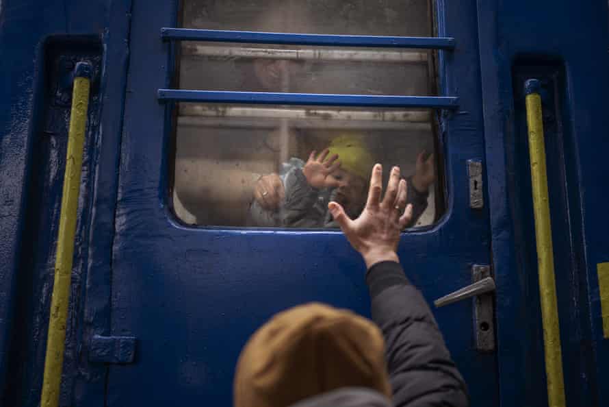 Stanislav says goodbye to his two-year-old son David and wife Anna after they boarded a train that will take them to Lviv, from the station in Kyiv, Ukraine.