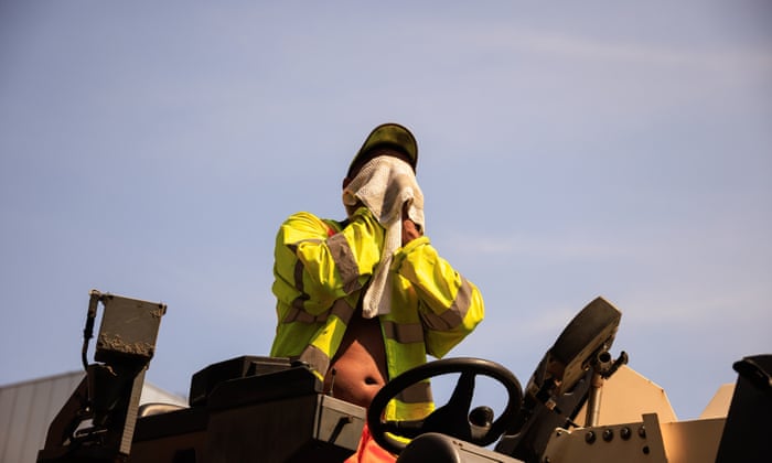 A construction worker digging up a road in the Northern Quarter in Manchester wipes sweat from his face.