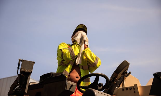 A construction worker in Manchester wipes sweat from his face.