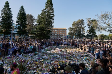 A crowd gathers on Wednesday in front of the floral tribute for the victims of the Hanukah festival shooting at Bondi beach.