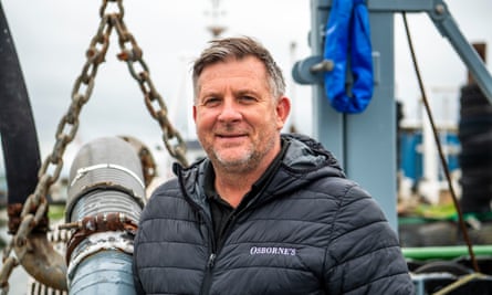 Graham Osborne in company-branded jacket next to some fishing equipment