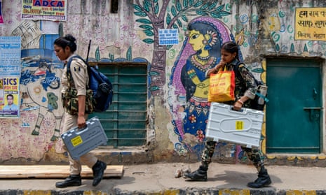 Security personnel carry Electronic Voting Machines (EVMs) and other voting materials as they leave for polling stations in Patna on 31 May 2024, on the eve of the seventh and final phase of voting in India’s general election