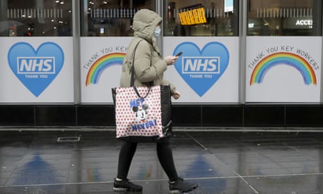 A woman walks past signs to support the NHS