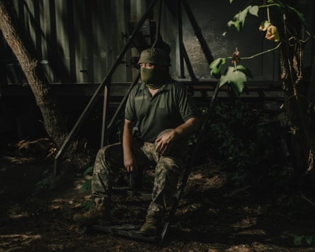 Soldier in army fatigues and wearing a green balaclava photographed at night