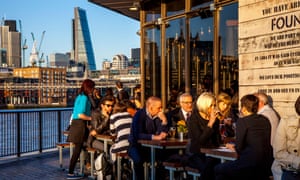 Office workers drinking at a riverside pub in London