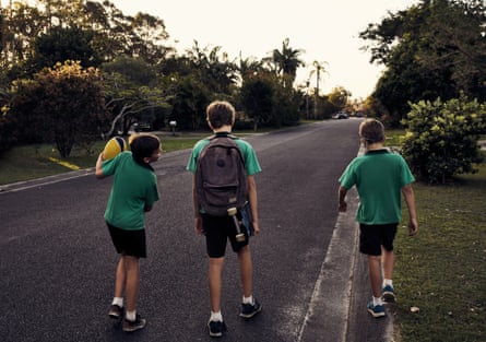 Three boys walking in the street wearing school uniforms