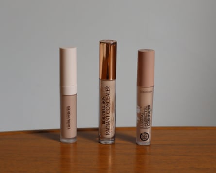 Three concealers stood on a wooden worktop