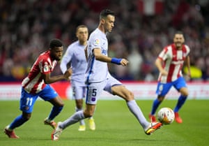 Barcelona’s Sergio Busquets is chased by Atletico Madrid’s Thomas Lemar.