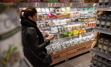 A shopper browses vegan produce at a supermarket.