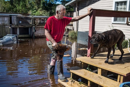George Aubert rescues one of his chickens from rising floodwaters caused by remnants of Hurricane Matthew on 11 October 2016 in Fair Bluff, North Carolina.
