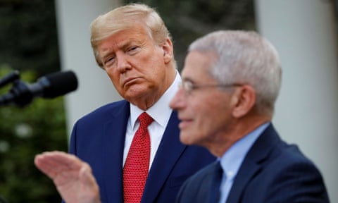 Anthony Fauci speaks as Donald Trump listens in the Rose Garden of the White House in late March.