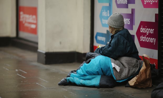 A homeless woman sits near Trafalgar Square, London