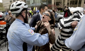 A Metropolitan police officer separates a protester from a member of the Turkish security detail in front of the Brookings Institute in Washington DC, 31 March. 