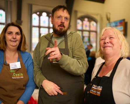 Jane Proctor, Mark Walmsley and Jakki Garner standing together in a church, pointing and smiling