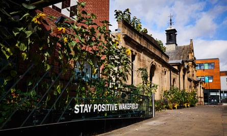 frontage of building with sunflowers and a sign saying ‘stay positive Wakefield’