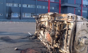 A burnt car that was allegedly torched by protesters, sits on the road after a violent rally in Wamena, Papua Province, Indonesia.