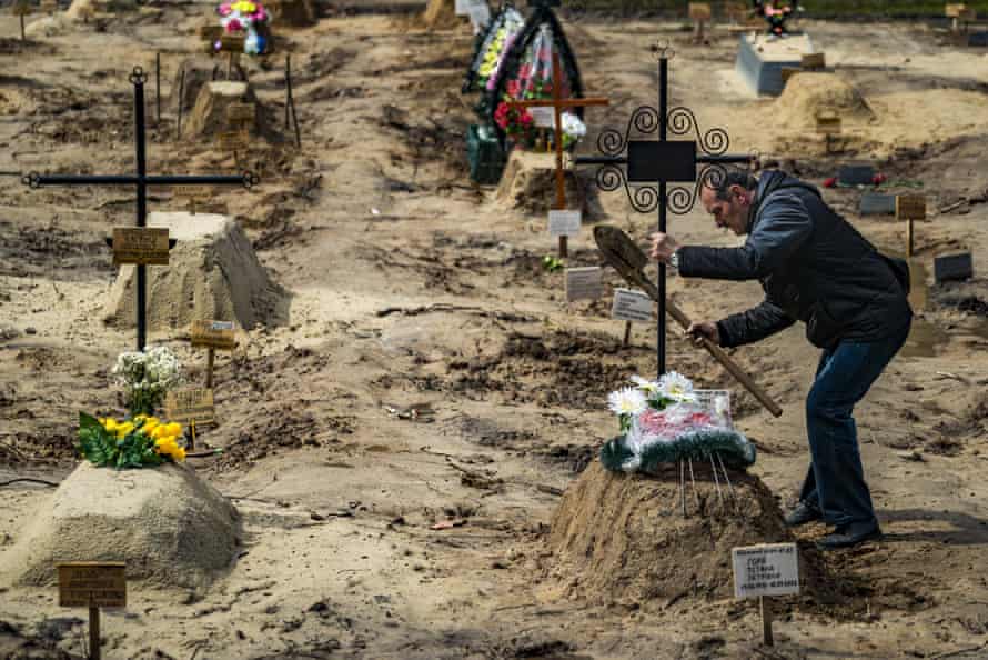 A man holds a cross after burying a relative killed in Chernihiv, Ukraine.