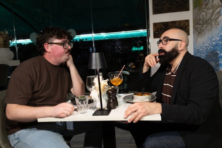 Two men facing each other across a restaurant table
